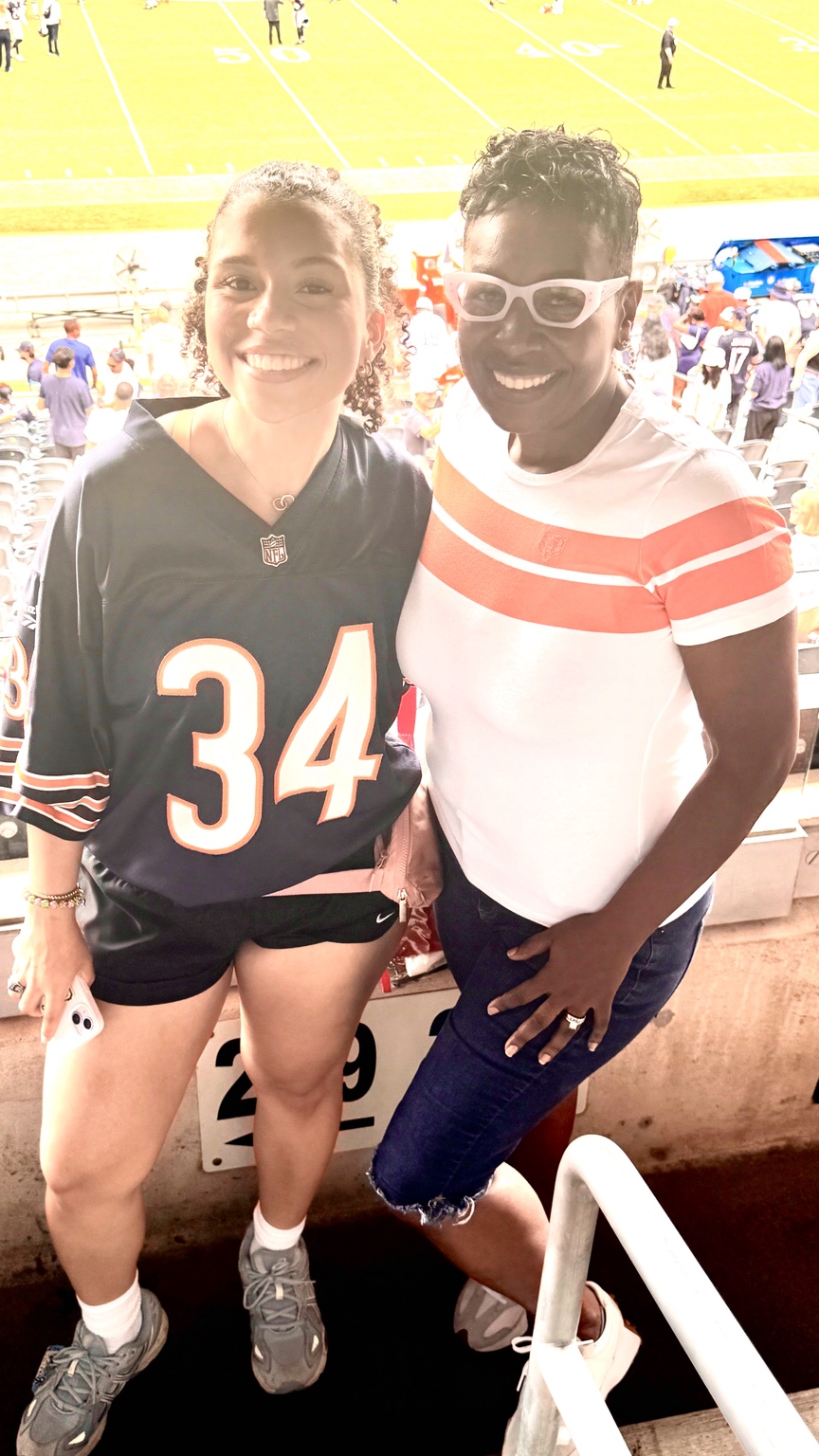 Two people in Chicago Bears apparel at a football game