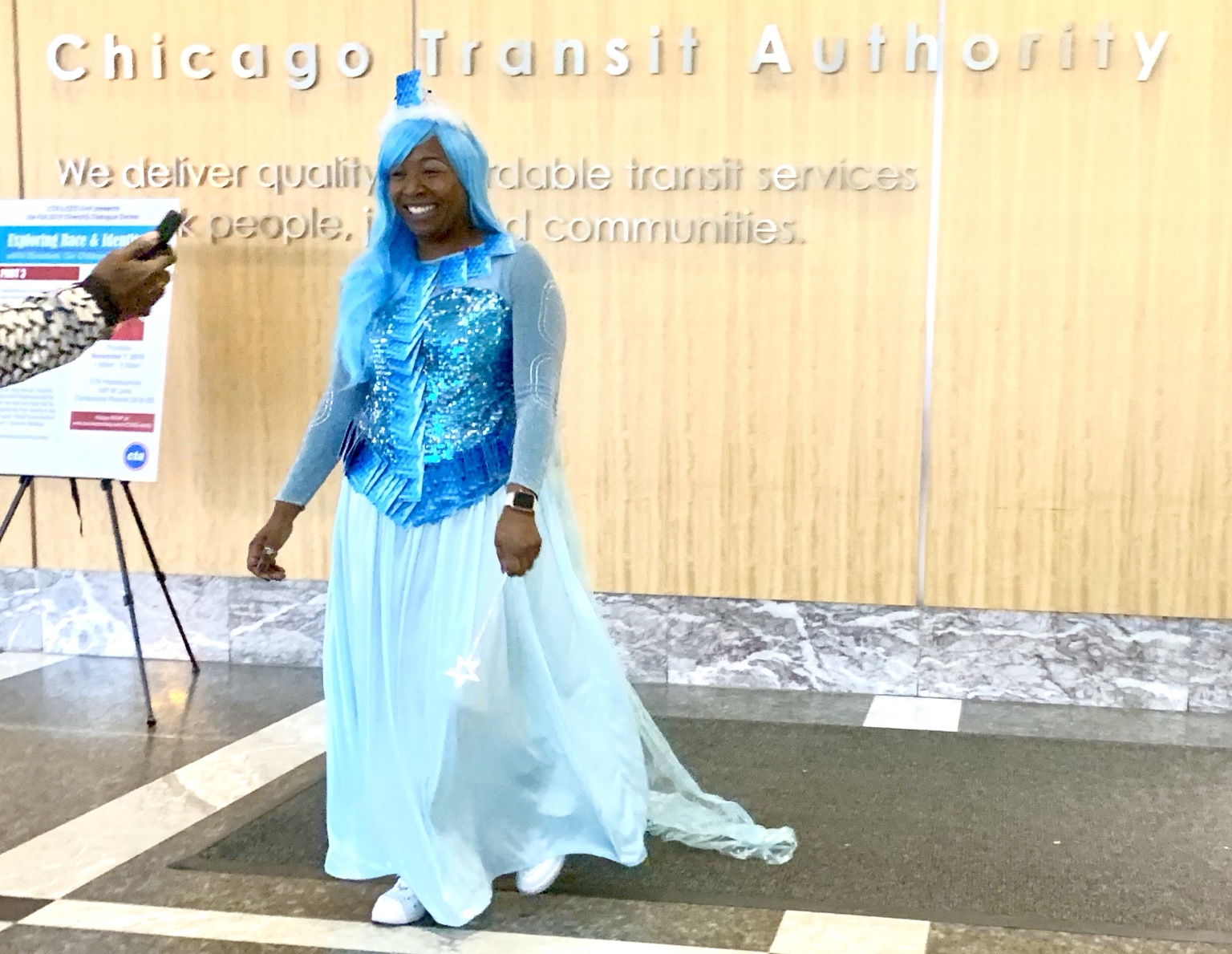 Wearing a bright blue costume in a Chicago Transit Authority lobby
