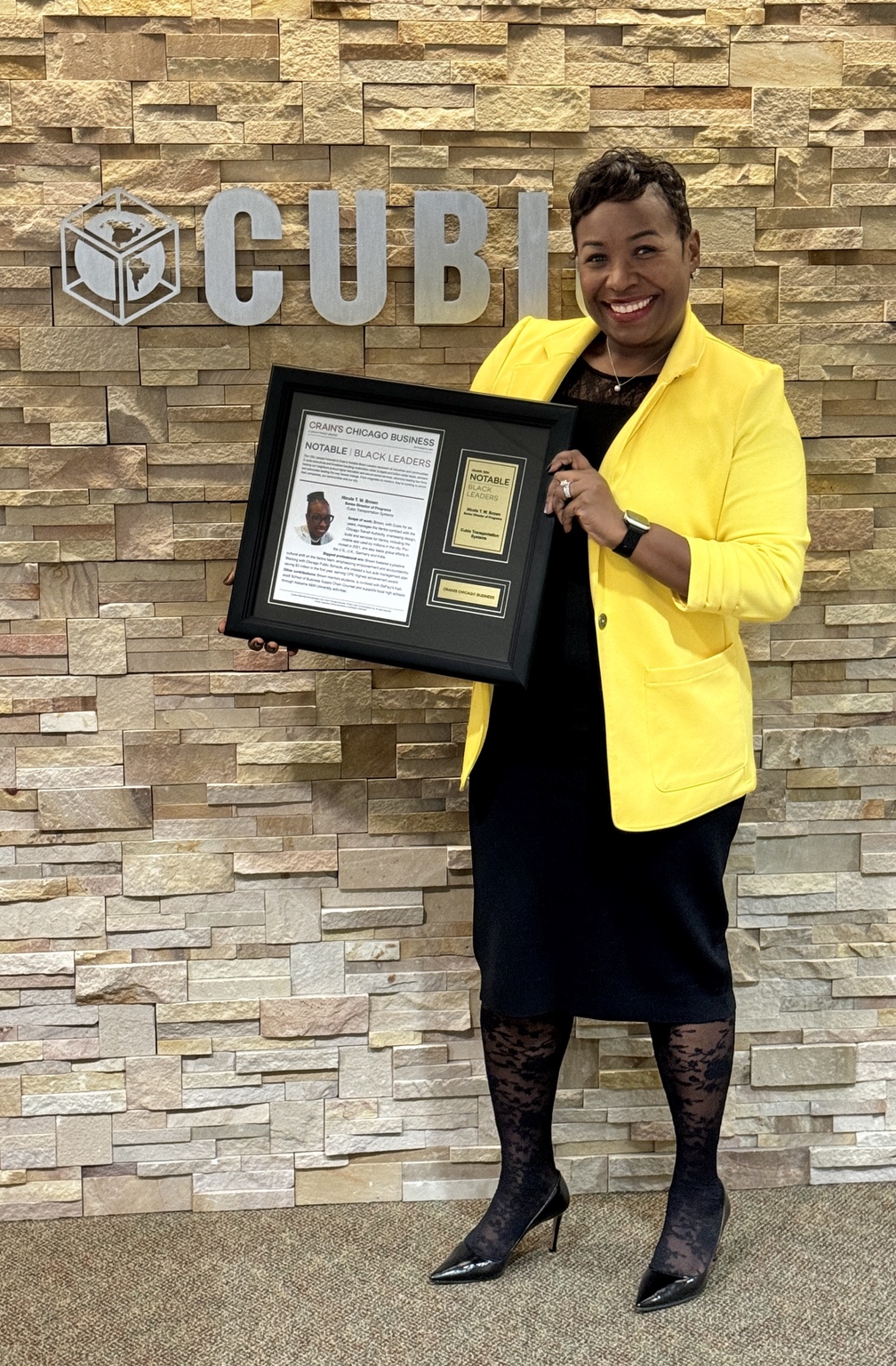 Holding a framed Crain’s Chicago Business Notable Black Leaders recognition in front of a Cubic sign